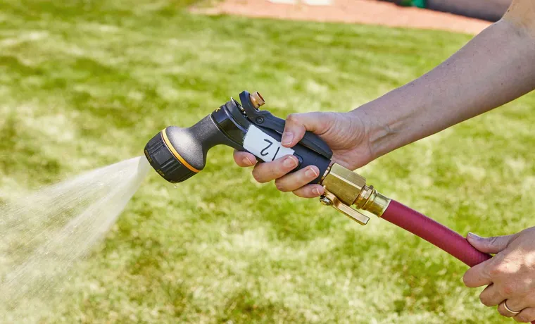 a garden hose ending with a nozzle is held vertically